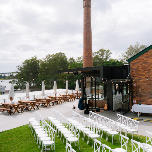Wedding ceremony chairs on the lawn beside the Engineers Hut, with the Rivermakers chimney behind.