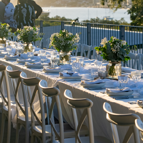 A long wedding table set on the terrace overlooking the Brisbane River.